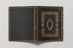 Open black book with gold decorative elements on a white background