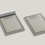 Two ttrpg map pads with decorative borders on a light gray background