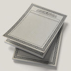 Stack of map pads with grid and decorative border on a light gray background