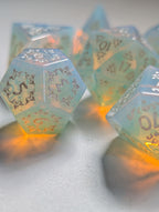 Close-up of The Moonveil opalite D&D dice showing pale blue, pearl, and warm reflective tones
