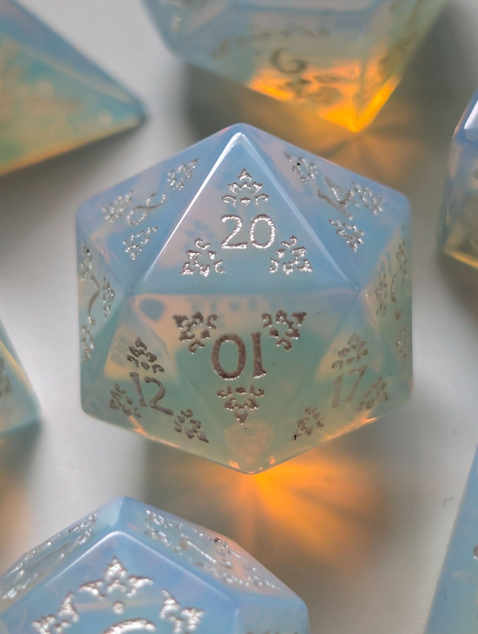 The Moonveil opalite D&D dice set with translucent blue tones and ornate silver numbering