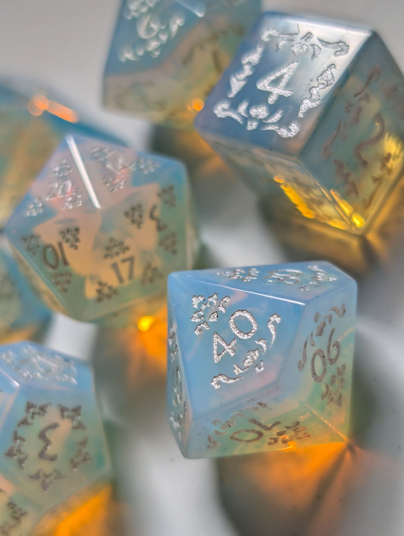 Detail view of The Moonveil opalite polyhedral dice with ornate silver numbering