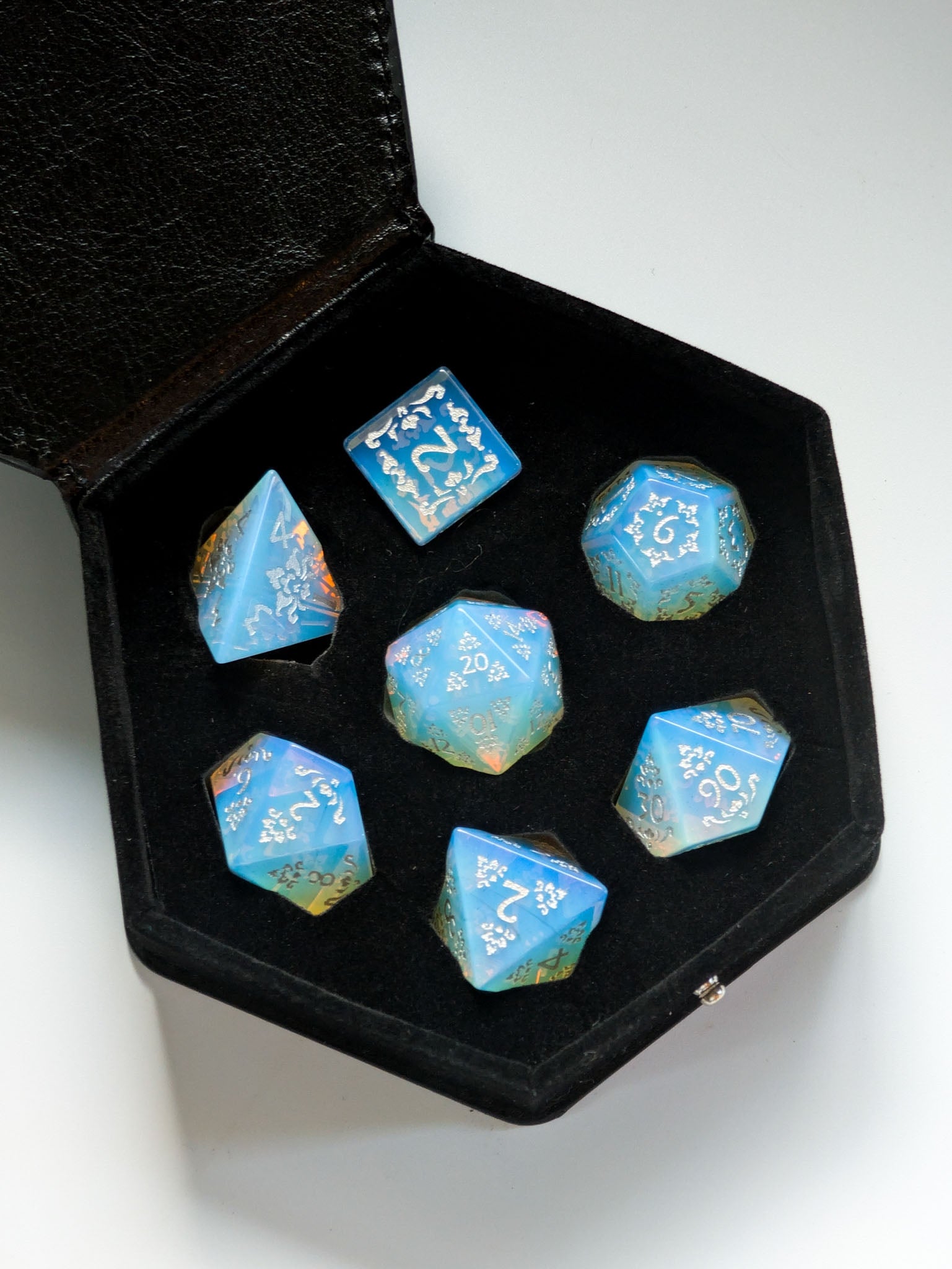 The Moonveil 7-piece opalite D&D dice set displayed inside its protective storage case