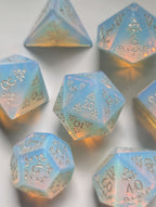 Angled view of The Moonveil 7-piece opalite D&D dice set with warm reflective tones