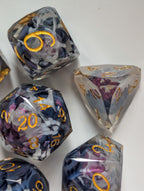Close-up of The Nightbloom gemstone-cut die with purple and black floral inclusions and gold numbering