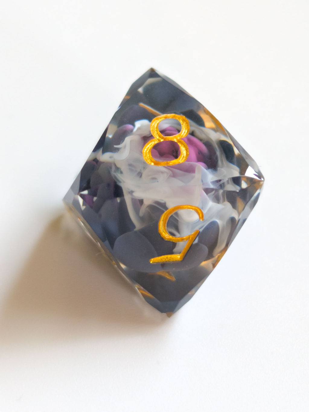 The Nightbloom gemstone-cut d8 D&D die with suspended dark floral detail and metallic gold numbers