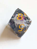 The Nightbloom gemstone-cut d8 D&D die with suspended dark floral detail and metallic gold numbers
