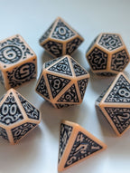 Angled view of The Relic 7-piece D&D dice set with ornate black designs