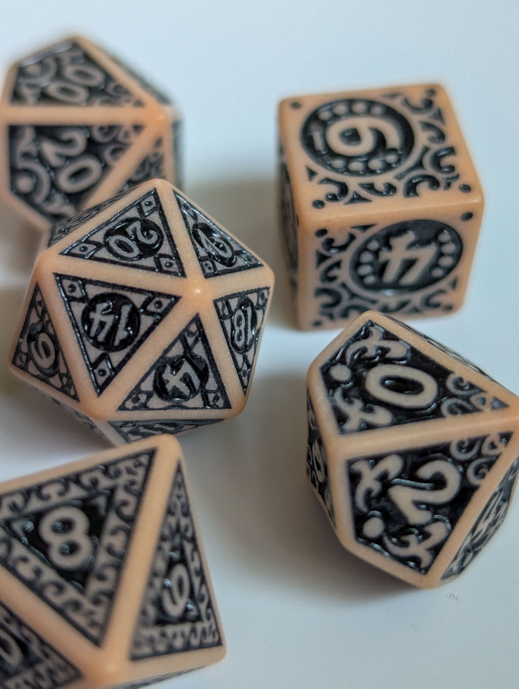 Detail view of The Relic D&D dice set showing decorative black patterns and numbered faces