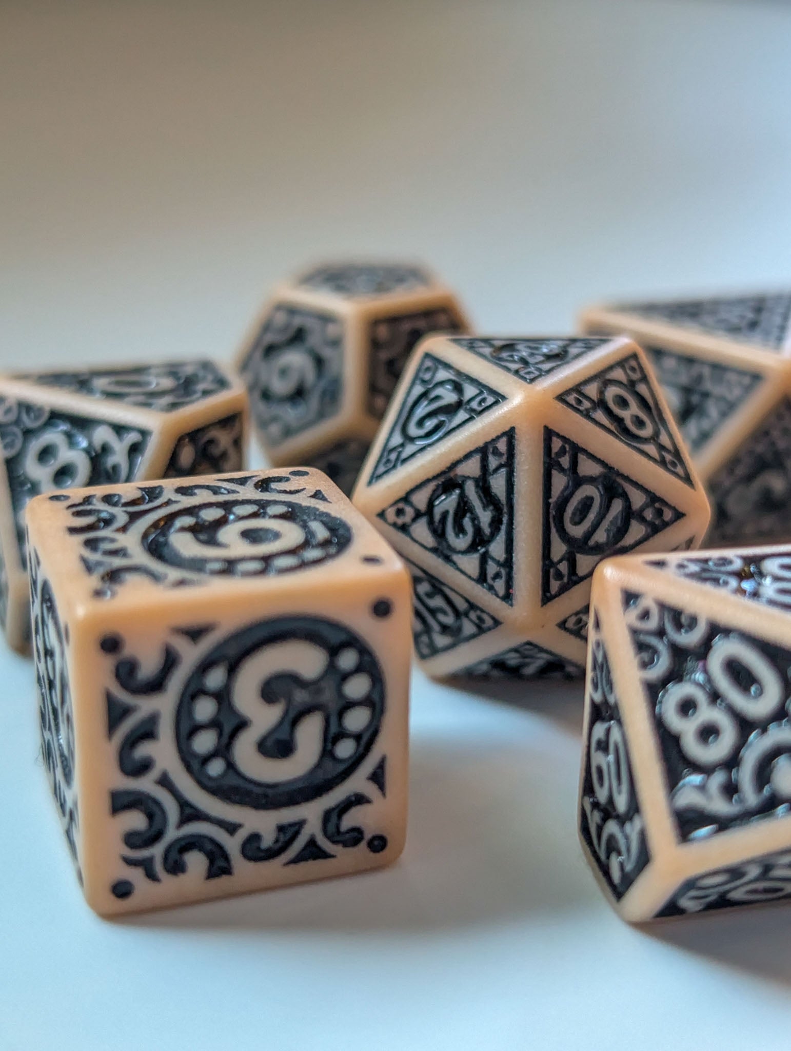The Relic D6 and matching polyhedral dice with antique-inspired black detailing